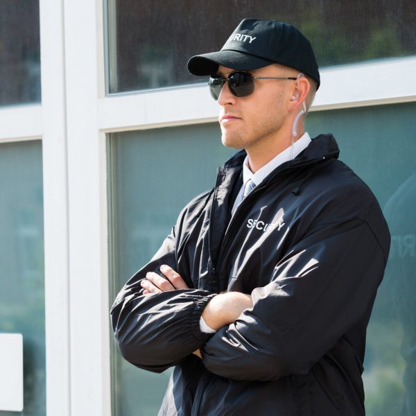 Young Male Security Guard Standing At The Entrance